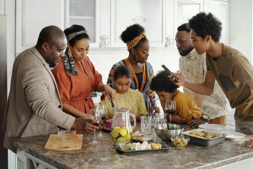 Adults and children cooking together in a large kitchen
