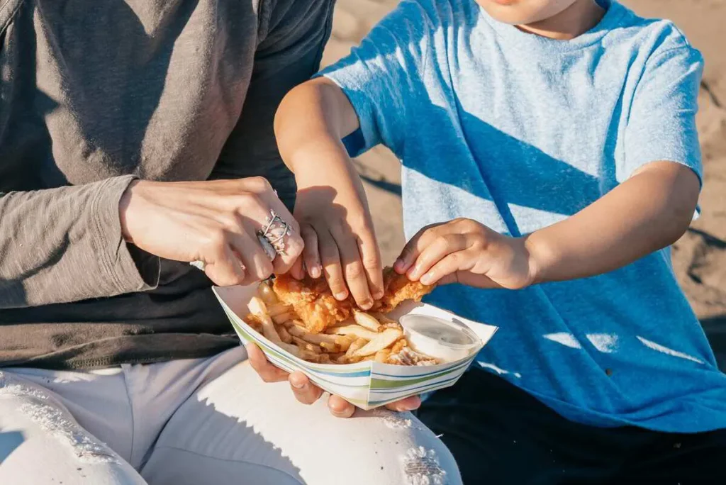 Child’s hands reaching into a bowl of crisps