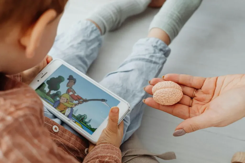 Child holding a tablet while an adult hand offers a snack