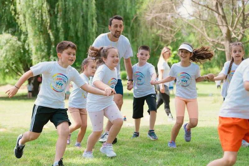 Children and adults running and playing together on the grass