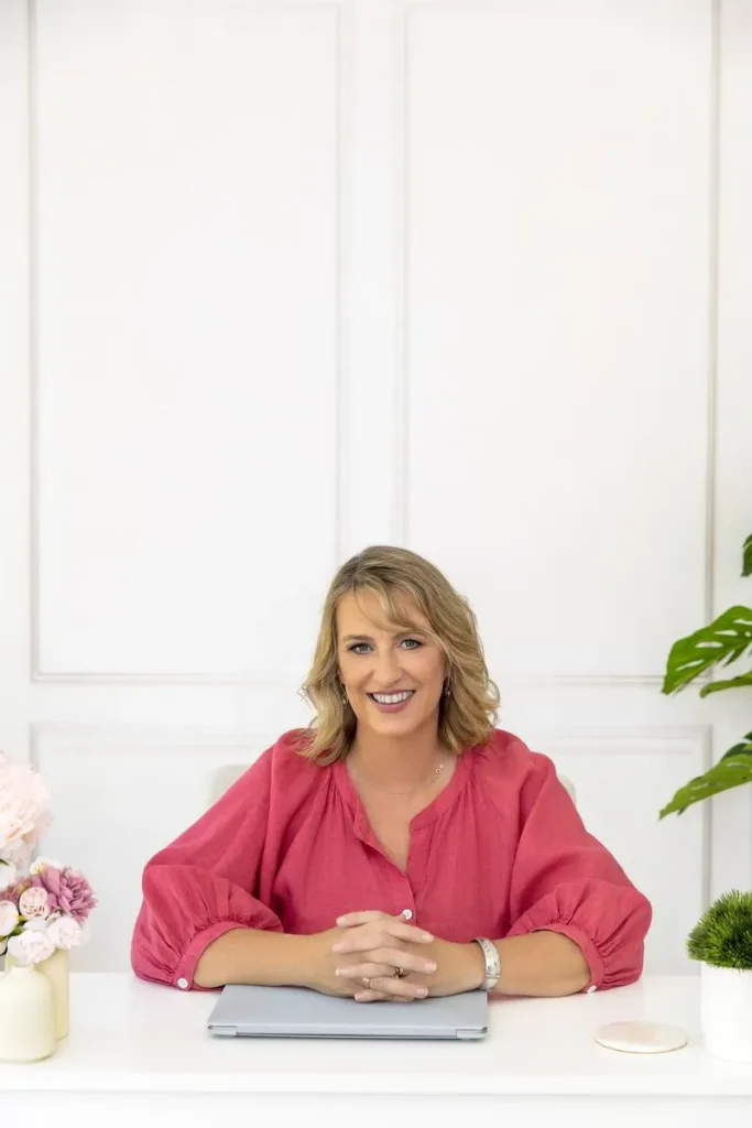 Emma Walker in a pink top sitting at a desk