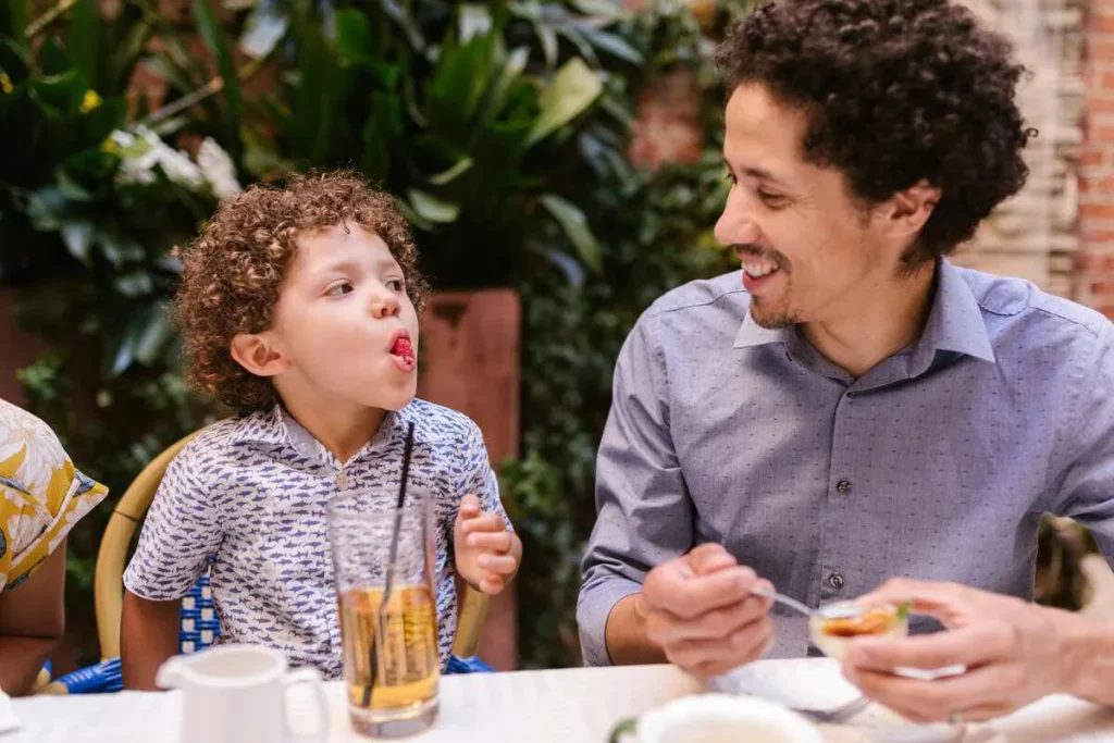 Father and young son enjoying a meal together at the table