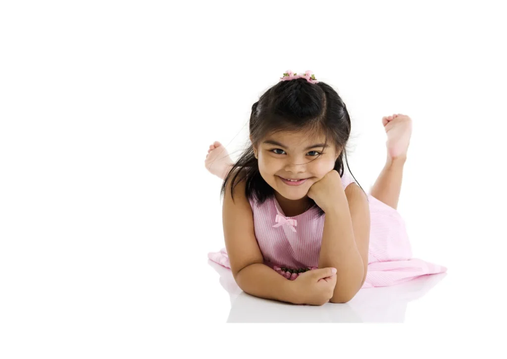 Smiling little girl lying on her stomach on a white background