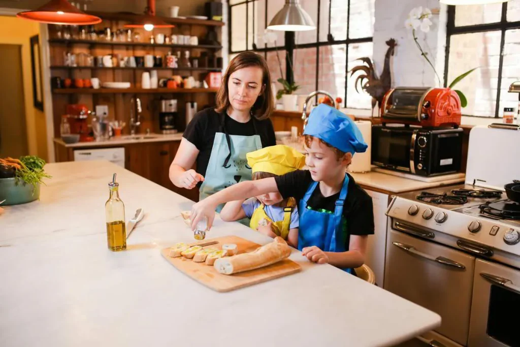 Mother and child in a chef hat preparing food together in the kitchen