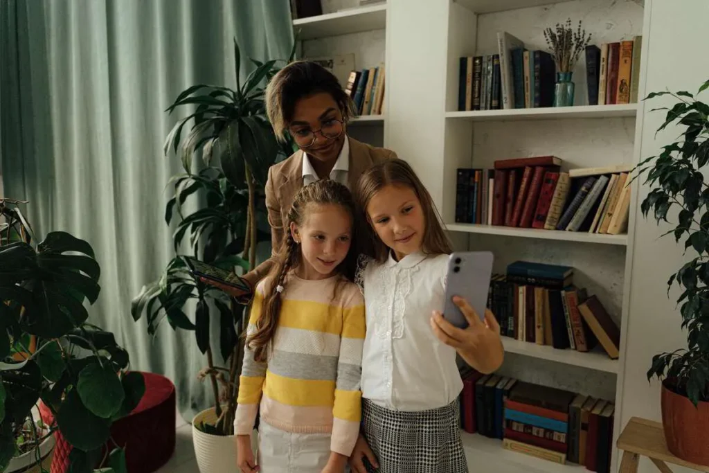 Mother and two girls standing in a living room, one holding a phone
