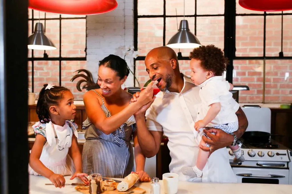 Parents and children cooking together in a busy family kitchen